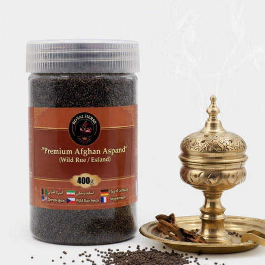 A clear plastic jar filled with dark wild rue seeds (Aspand/Esfand), labeled "Premium Afghan Aspand (Wild Rue / Esfand) 400g" by Royal Herbs, placed next to an ornate brass incense burner with white smoke rising. Some seeds are scattered in the foreground on a clean white background.