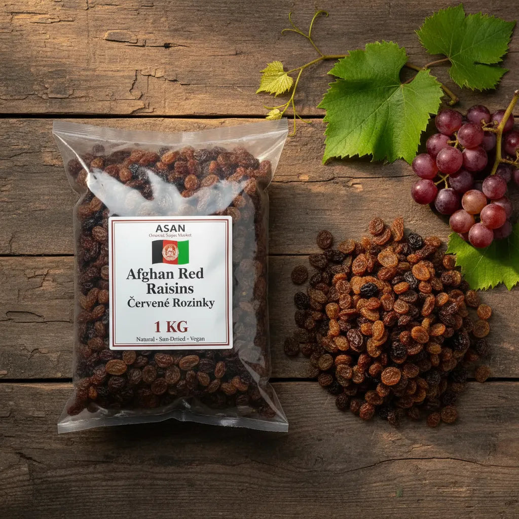Packaged Afghan Red Raisins with a label on a wooden surface, accompanied by some raisins and grapes.